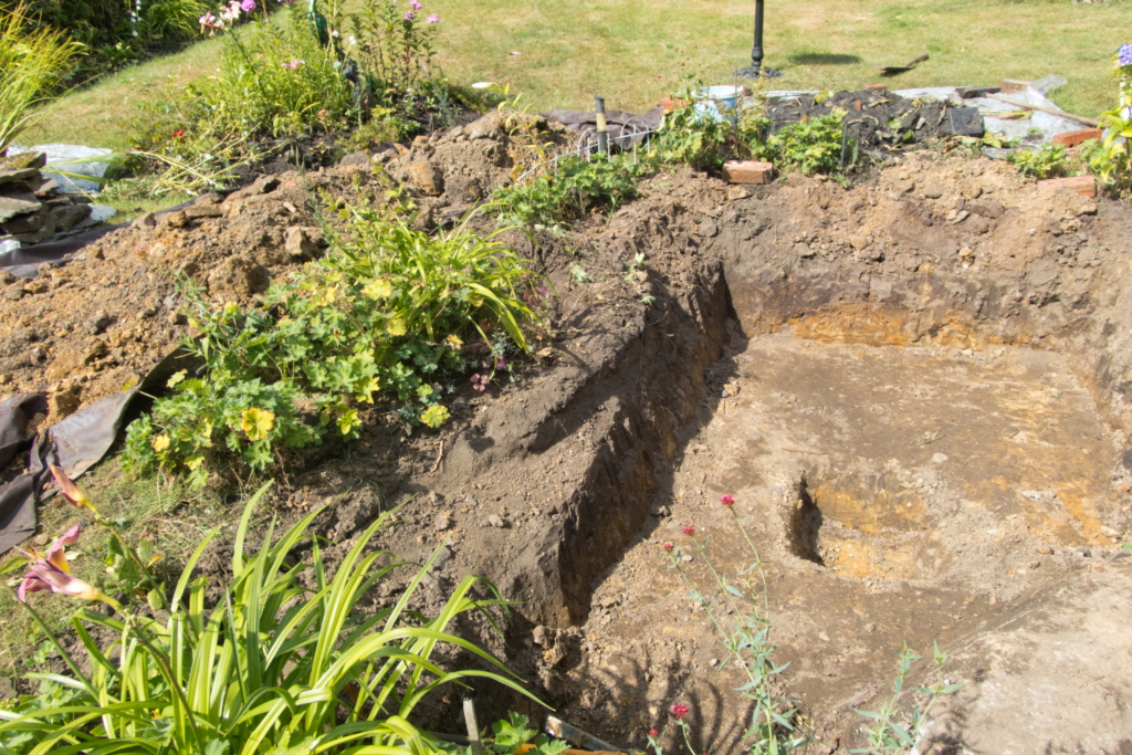 a square hole dug in the ground for a pond