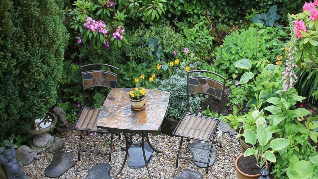 a cozy rock patio with a table and two chairs surrounded by plants