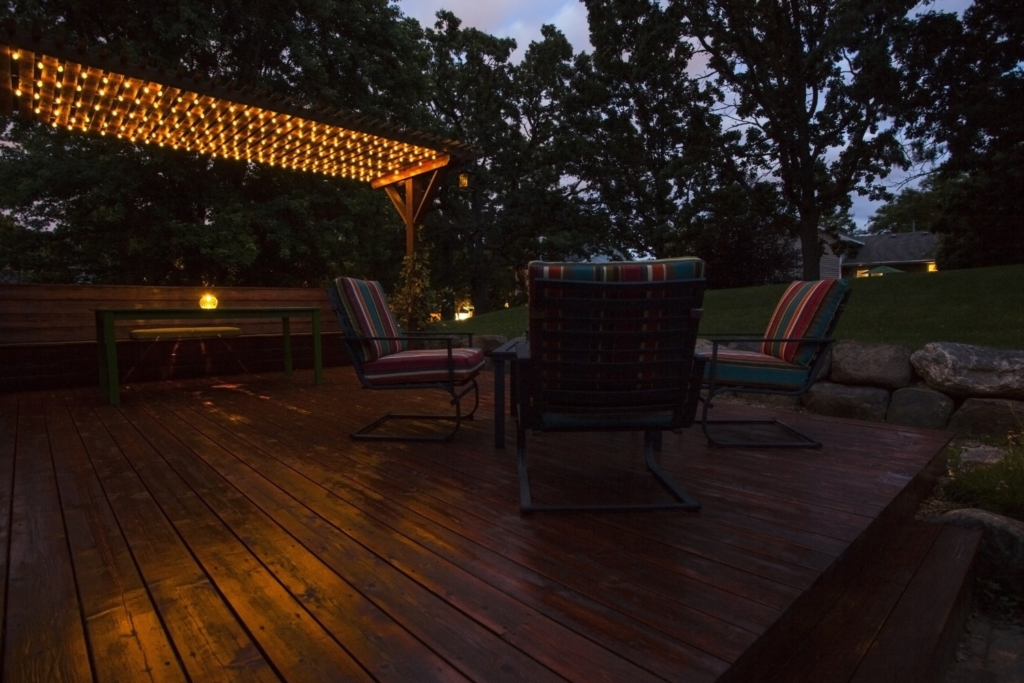 patio furniture on a wood patio with a pergola with string lighting