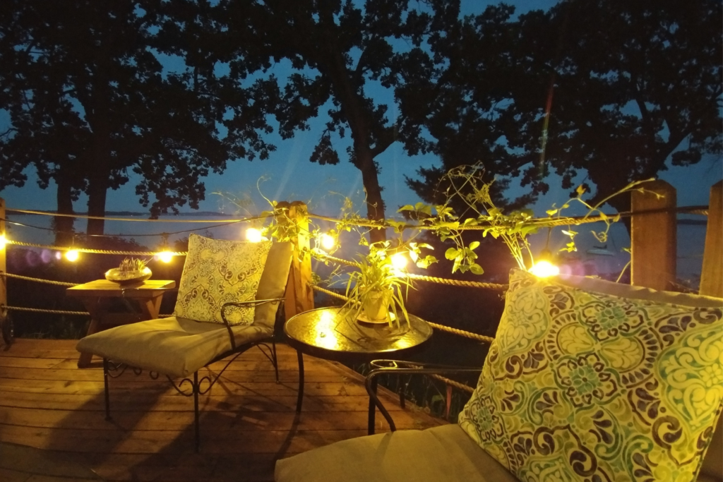 outdoor patio furniture on a wood deck with string lights