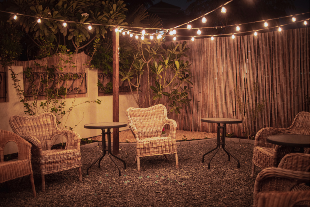 string lighting over patio chairs in a backyard