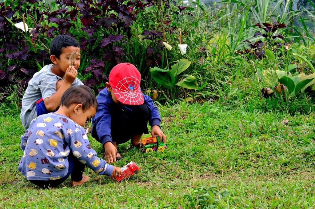 three children playing in the grass