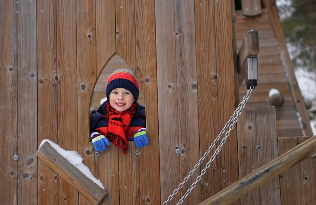 child looking out the window of an outdoor playground