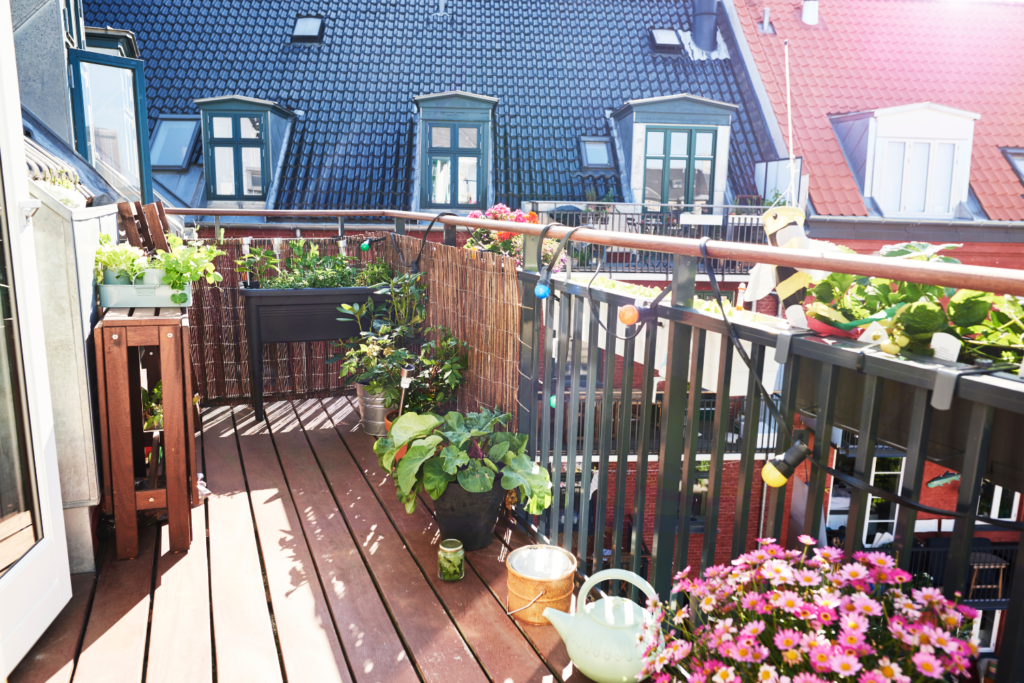 Apartment balcony patio covered in vegetable garden raised bed containers and string lights