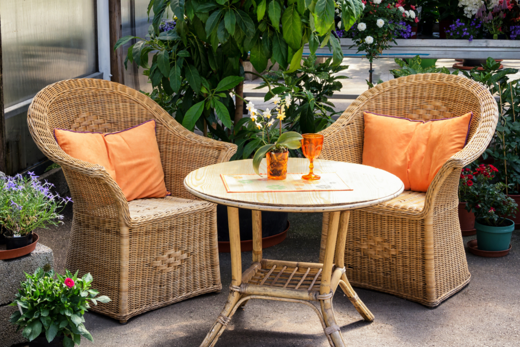 Patio balcony seating with 2 wicker chairs and orange pillows