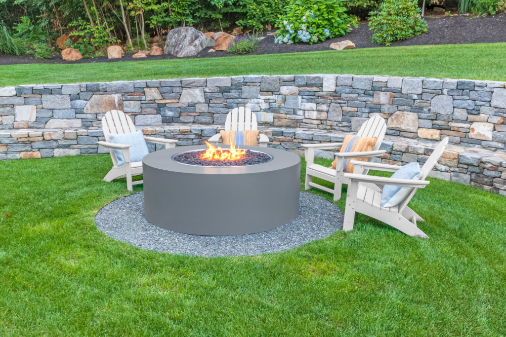 gas firepit with chairs in a backyard