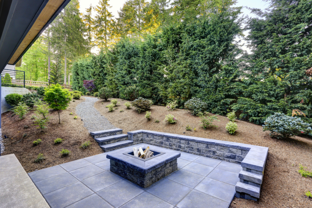 fire pit on stone patio surrounded by trees